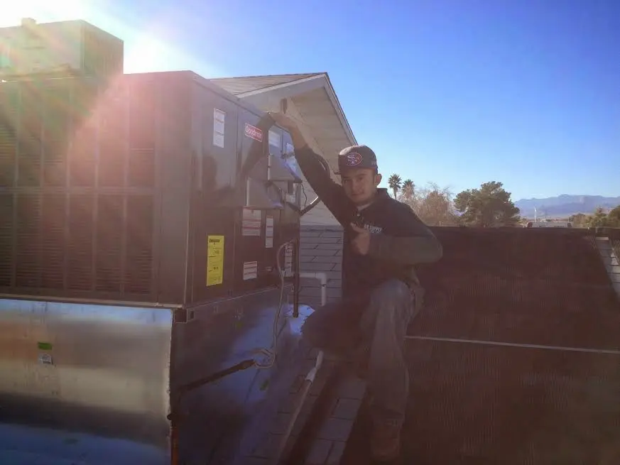 HVAC technician performing Air Duct Cleaning on a rooftop unit in Meridianville